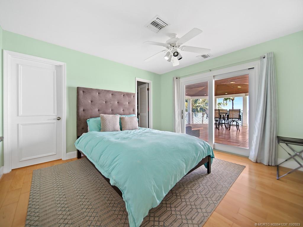 10 Island Road Stuart, FL 34996 - Photo 49 of 60 a bedroom with a large bed and a chandelier
