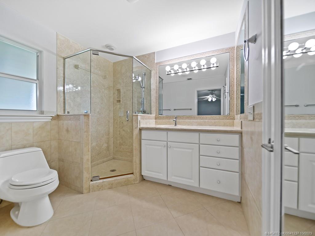 10 Island Road Stuart, FL 34996 - Photo 50 of 60 a spacious bathroom with a shower a sink and a mirror