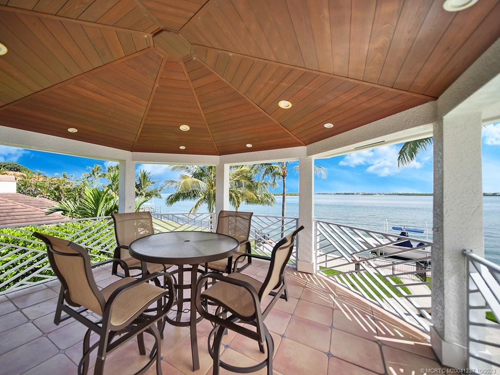 10 Island Road Stuart, FL 34996 - Photo 53 of 60 a patio with a table and chairs and potted plants
