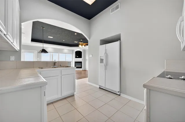 a kitchen with white cabinets and white appliances