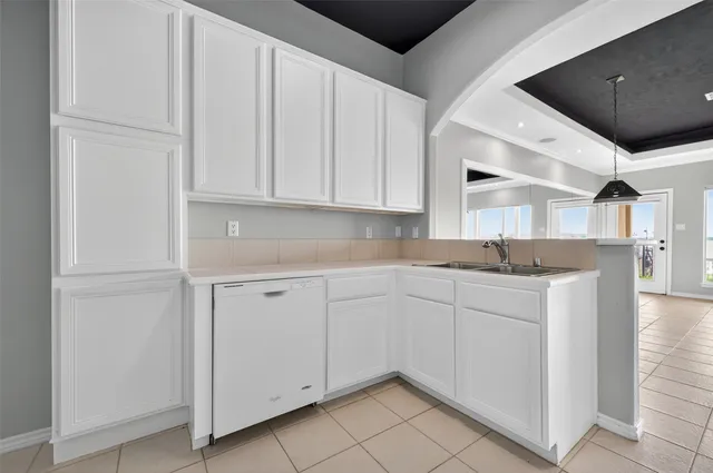 a kitchen with white cabinets and white appliances
