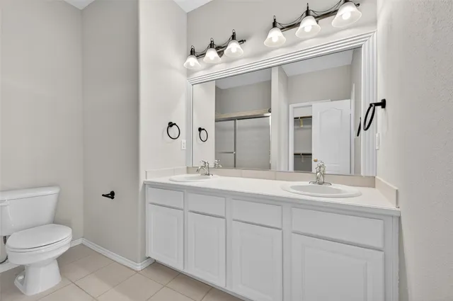 a view of an empty room with chandelier fan and wooden floor