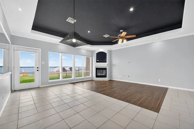 an empty room with windows and fireplace