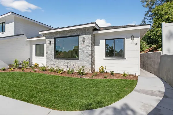 a living room with fireplace furniture and a potted plant