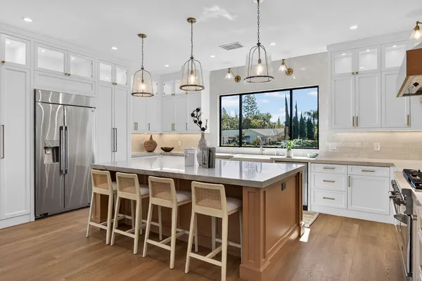 a kitchen with granite countertop a sink appliances counter top space and living room view