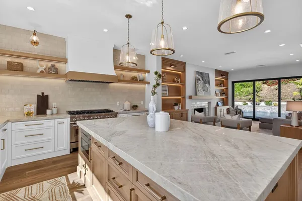 a kitchen with stainless steel appliances granite countertop a sink a stove and a wooden floors