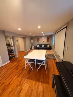 a room with wooden floor pool table and chairs