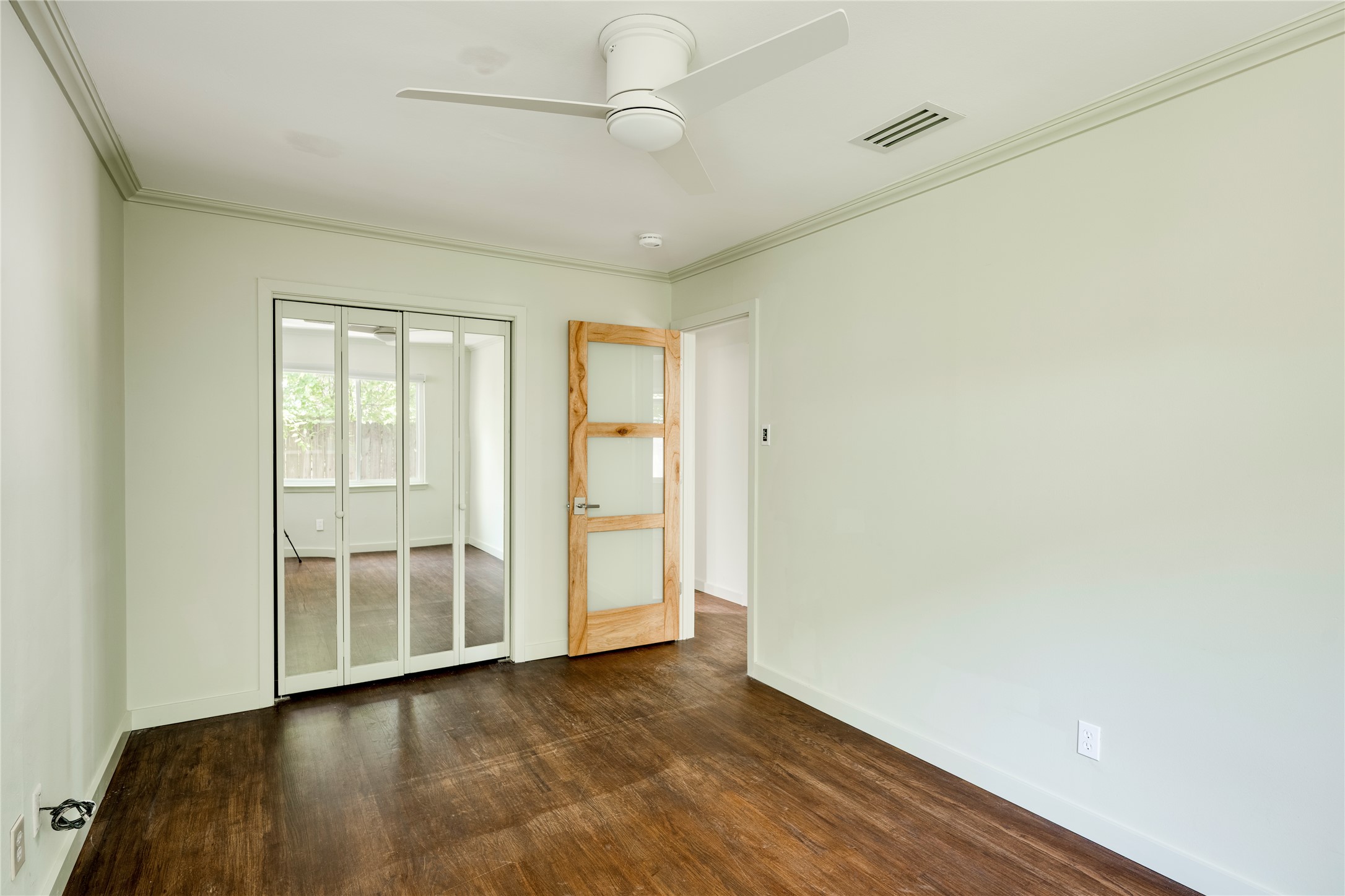 1707 Overhill Drive Austin, TX 78721 - Photo 14 of 36 Rich hardwood-style flooring extends across this room, complemented by a modern ceiling fan for comfort.