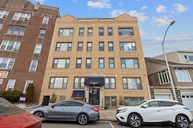 a front view of a residential apartment building with a parking space