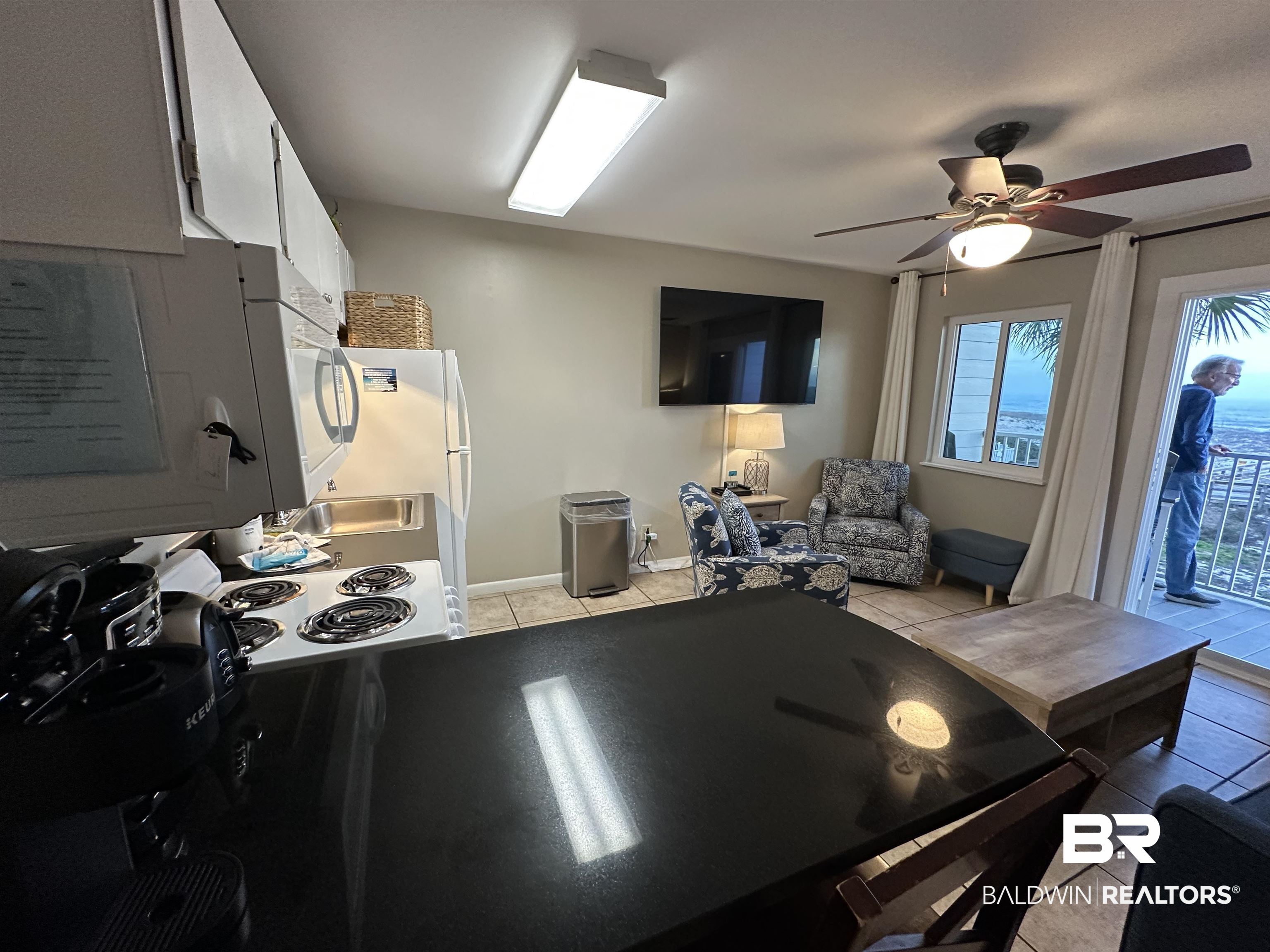 400 Plantation Road, Unit 2202 Gulf Shores, AL 36542 - Photo 20 of 26 Kitchen featuring light tile patterned floors, white cabinets, freestanding refrigerator, a ceiling fan, and range with electric cooktop