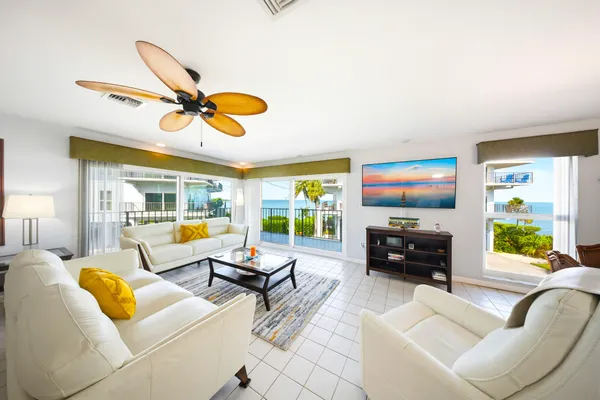 a living room with furniture and a flat screen tv with kitchen view