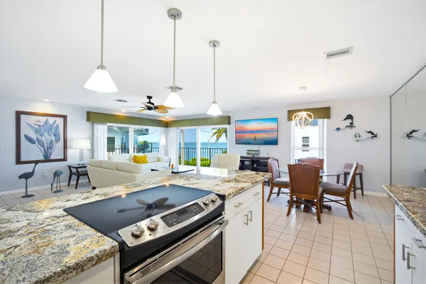 a kitchen with a stove a sink a dining table and chairs with wooden floor