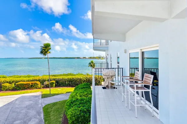 a view of a swimming pool with a chair and tables in the patio
