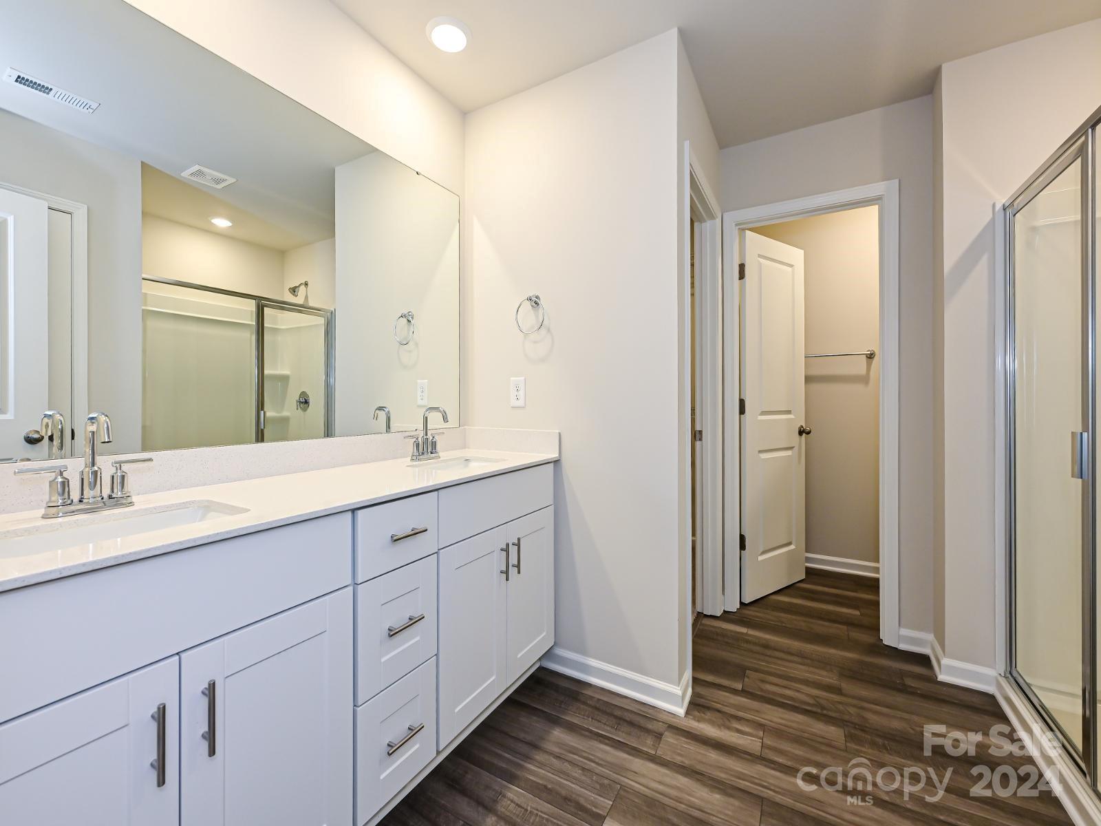 3840 Backwater Street Concord, NC 28027 - Photo 17 of 23 a spacious bathroom with a double vanity sink a mirror and a shower
