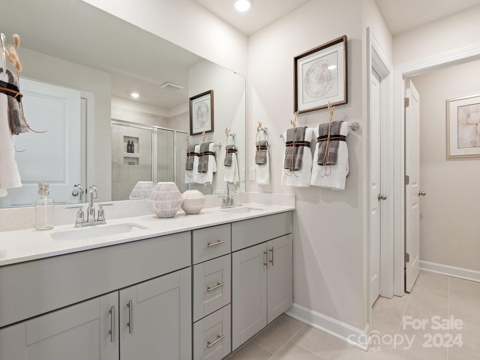 3840 Backwater Street Concord, NC 28027 - Photo 19 of 23 a bathroom with double vanity sinks a vanity a mirror and shower