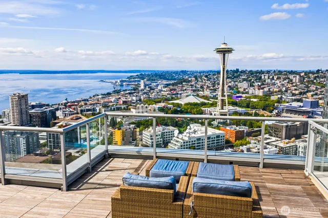 a roof deck with couches and sky view