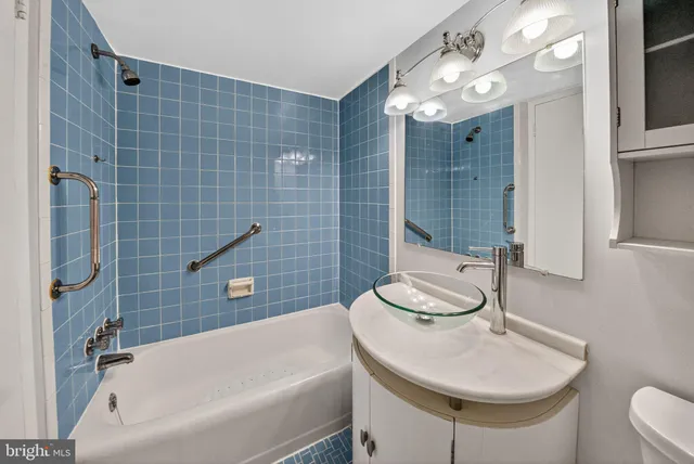 a bathroom with a sink a toilet a mirror and shower