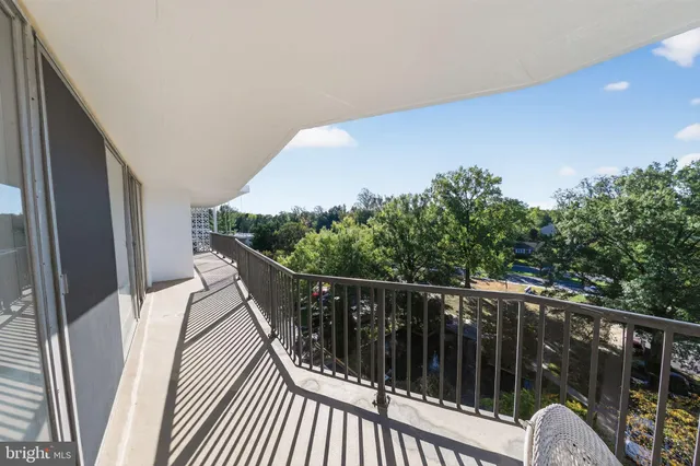 a balcony with wooden floor and outdoor seating
