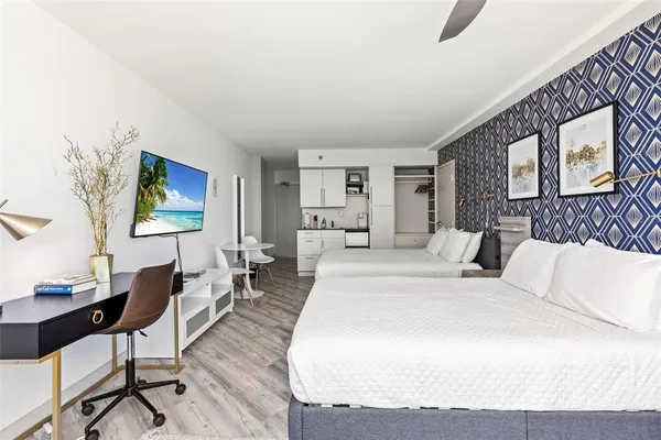 a spacious bedroom with a bed a couch and a dresser in it