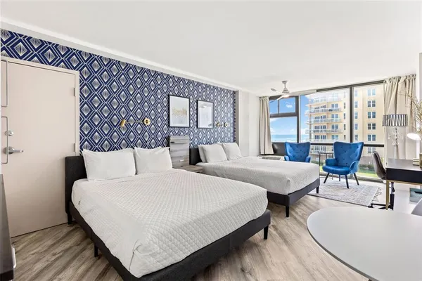 a bedroom with two beds and a large window