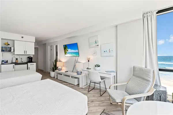 a living room with furniture and a refrigerator