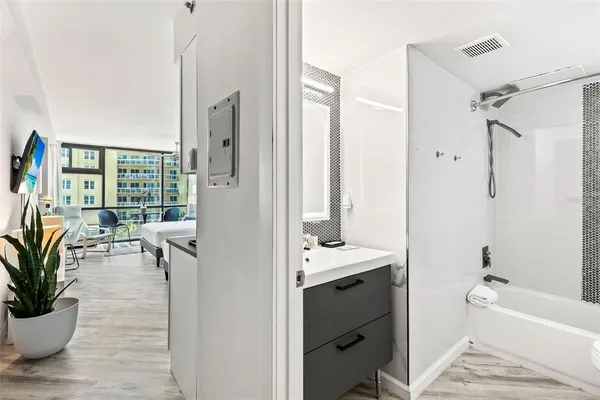 a bathroom with a tub sink and mirror