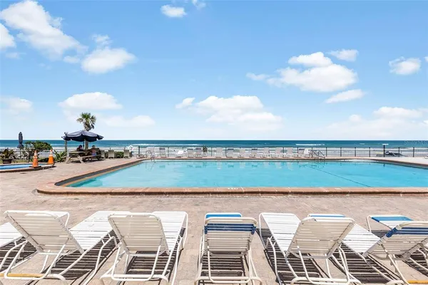 a view of swimming pool with outdoor seating and city view