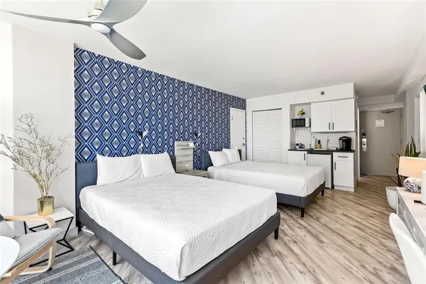 a spacious bedroom with a bed and a lamp with the wooden floor