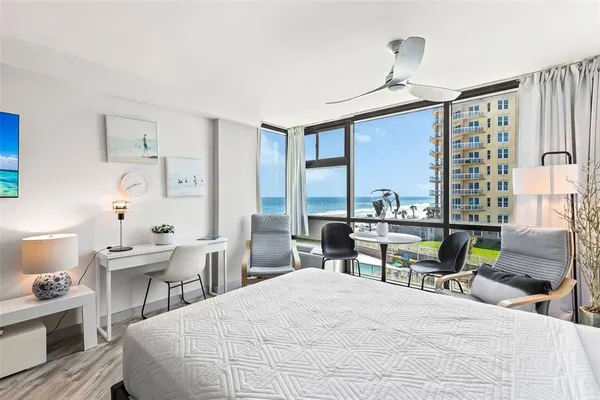 a bedroom with a bed a large window and table