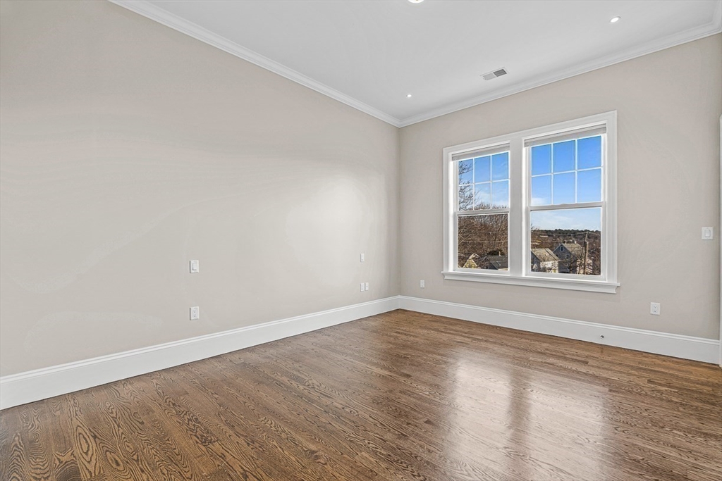 846 Main Street, Unit 3 Winchester, MA 01890 - Photo 13 of 36 a view of an empty room with wooden floor and a window