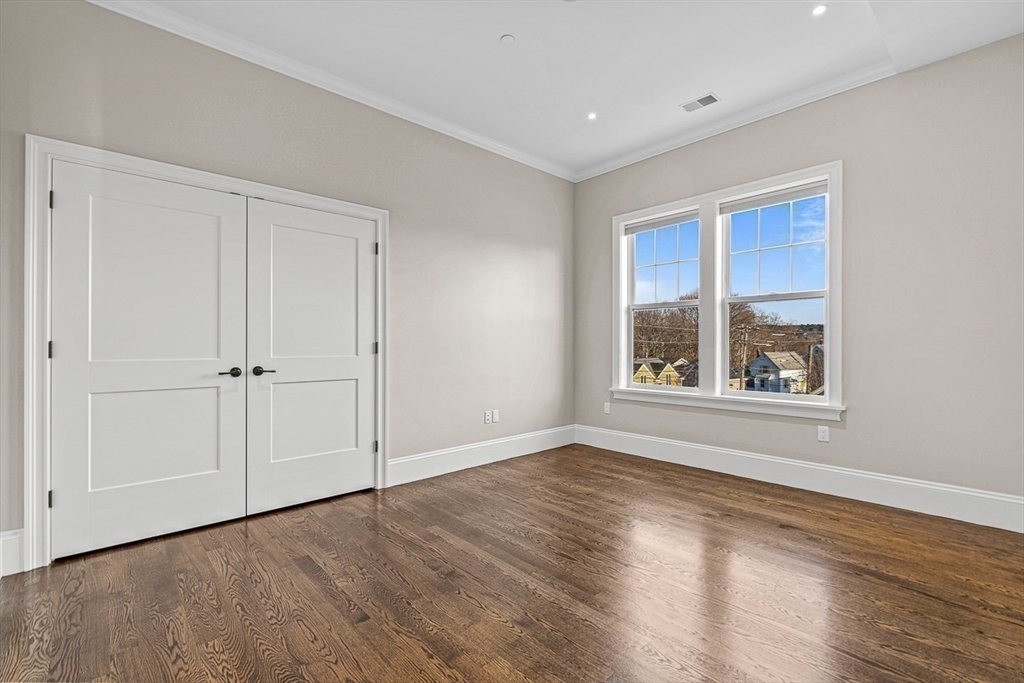 846 Main Street, Unit 3 Winchester, MA 01890 - Photo 15 of 36 a view of an empty room with wooden floor and a window