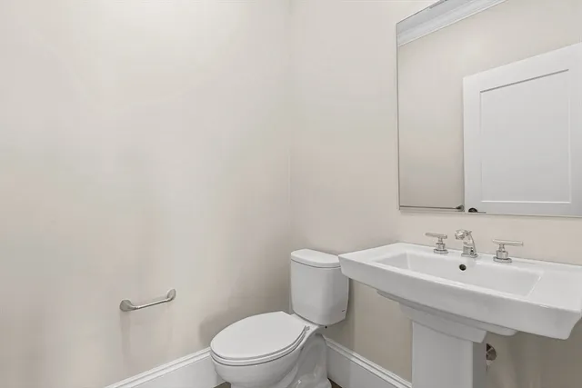 a white toilet sitting next to a bathroom sink