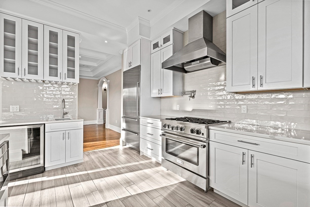 846 Main Street, Unit 3 Winchester, MA 01890 - Photo 21 of 36 a kitchen with stainless steel appliances granite countertop a stove and white cabinets