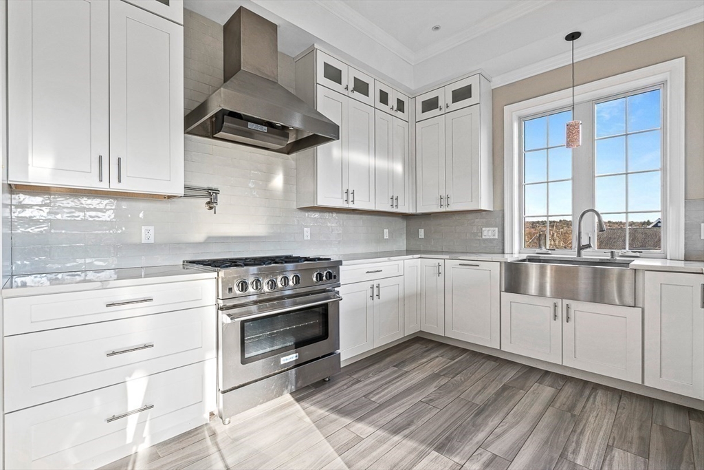 846 Main Street, Unit 3 Winchester, MA 01890 - Photo 25 of 36 a kitchen with white cabinets and appliances