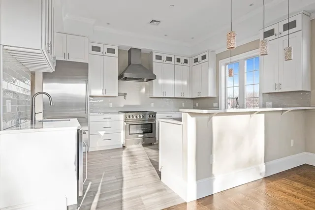 a kitchen with stainless steel appliances a sink a stove and a refrigerator