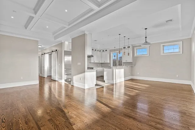 a living room with wooden floor and white walls