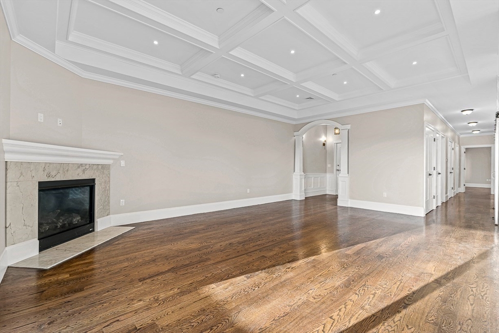 846 Main Street, Unit 3 Winchester, MA 01890 - Photo 5 of 36 an empty room with wooden floor and fireplace