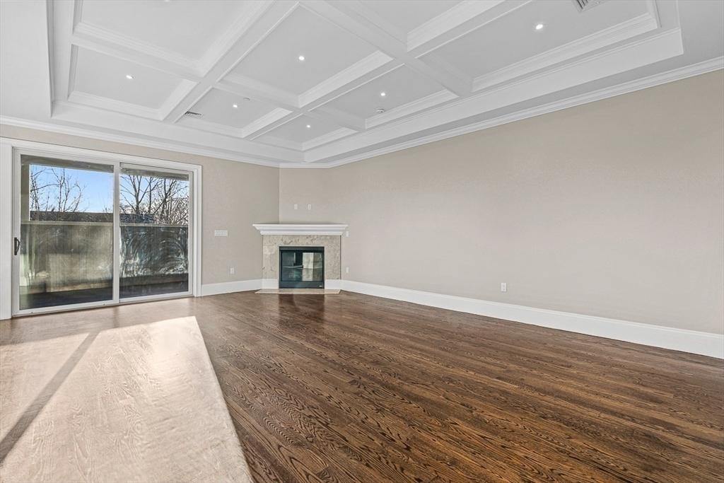 846 Main Street, Unit 3 Winchester, MA 01890 - Photo 6 of 36 en empty room with wooden floor and fireplace