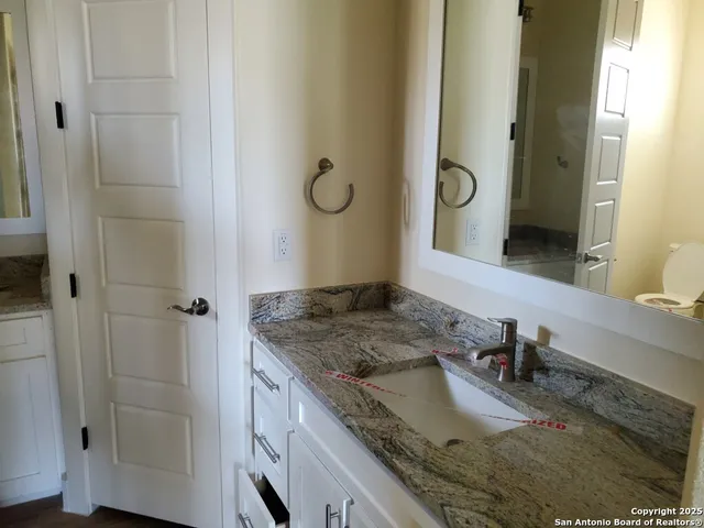 a bathroom with a granite countertop sink and a mirror