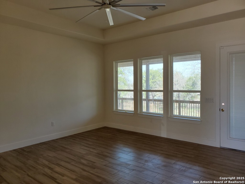 65 Nine Patch Drive Poteet, TX 78065 - Photo 4 of 14 an empty room with wooden floor fan and windows