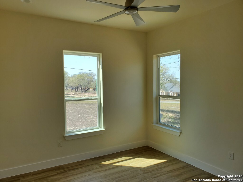65 Nine Patch Drive Poteet, TX 78065 - Photo 5 of 14 a view of an empty room with wooden floor and a window