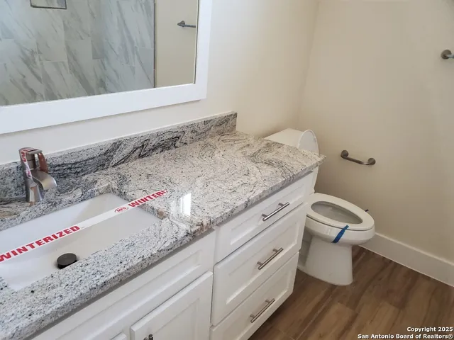 a bathroom with a granite countertop sink and a mirror