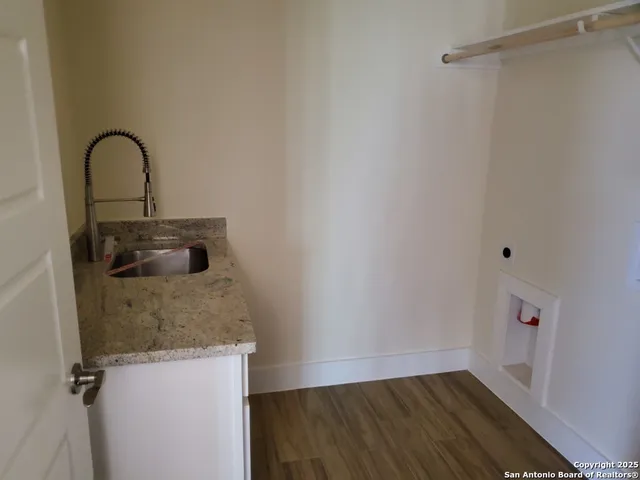 a close view of a faucet a sink and cabinets in room