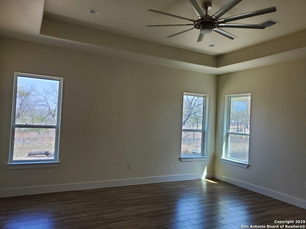 65 Nine Patch Drive Poteet, TX 78065 - Photo 10 of 14 a view of an empty room with wooden floor and window
