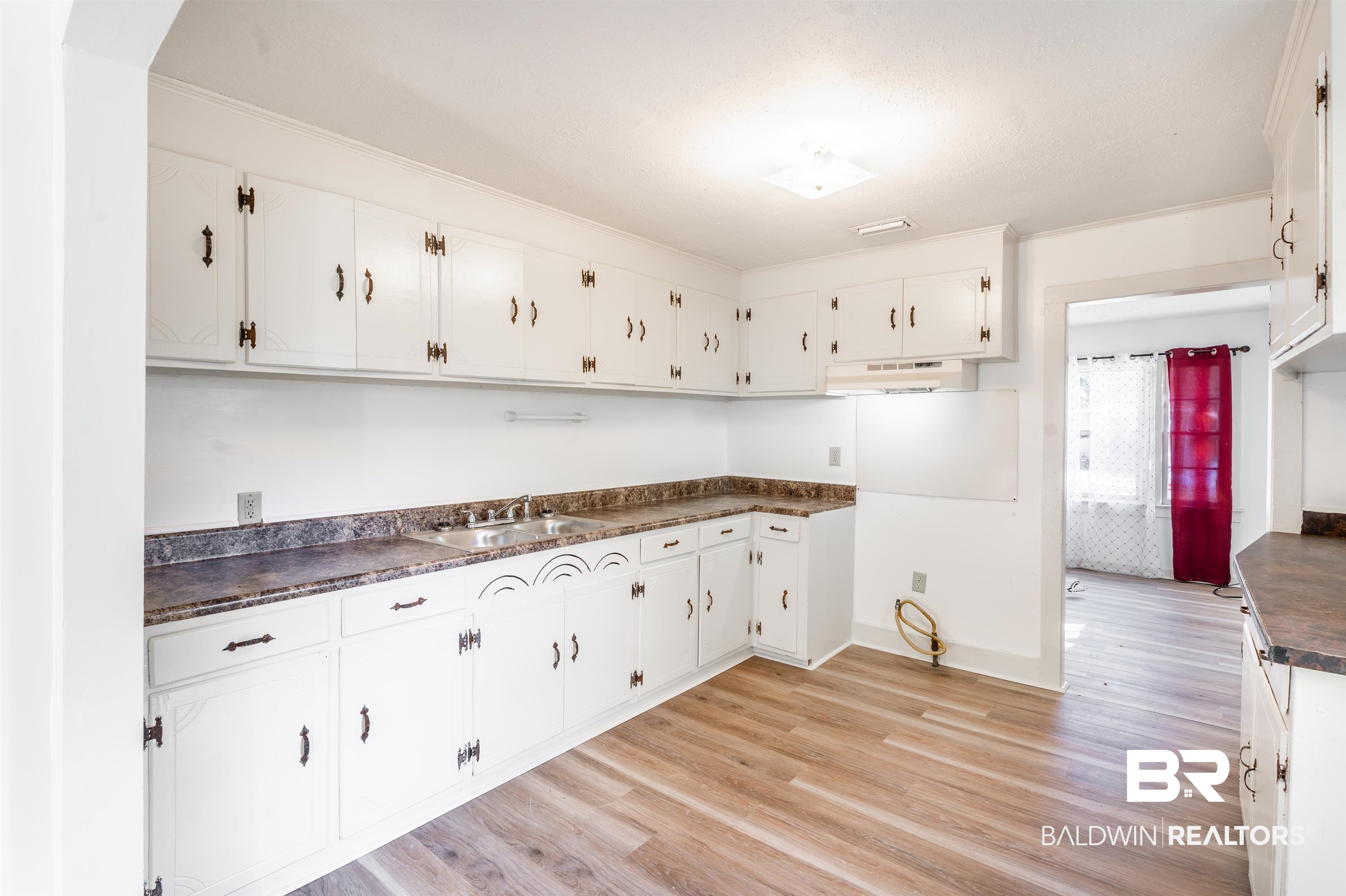 3900 Brookmont Drive Mobile, AL 36605 - Photo 6 of 19 Kitchen with sink, light hardwood / wood-style floors, and white cabinetry