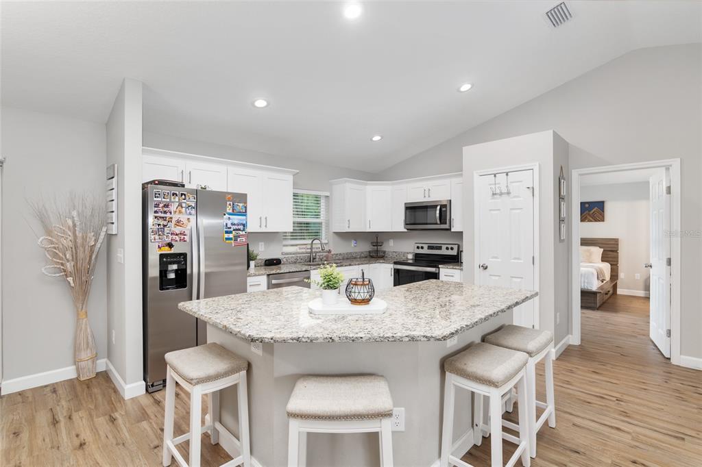 12 Oak Circle Pass Ocala, FL 34472 - Photo 16 of 50 a kitchen with stainless steel appliances granite countertop a dining table chairs refrigerator and microwave