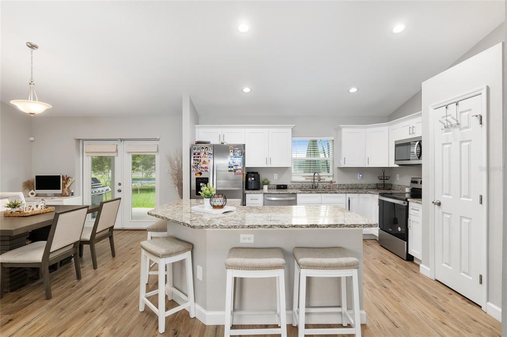 12 Oak Circle Pass Ocala, FL 34472 - Photo 18 of 50 a kitchen with stainless steel appliances granite countertop a stove top oven a refrigerator a sink and white cabinets with wooden floor