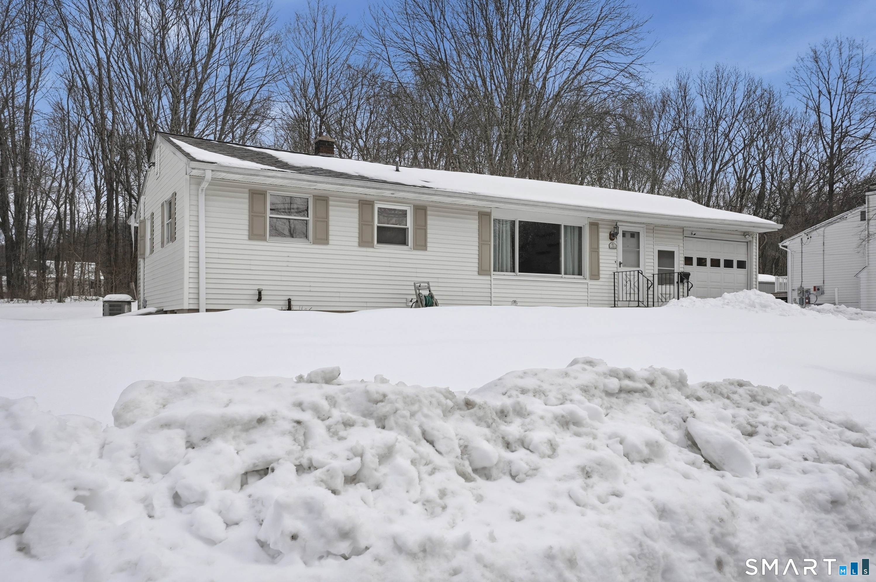 a view of a white house with a yard covered in snow