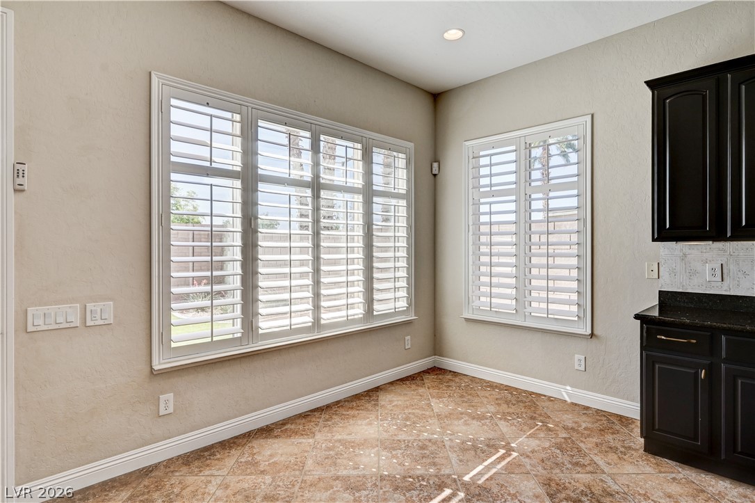 2793 Rosenhearty Drive Henderson, NV 89044 - Photo 15 of 77 Plantation shutters adorn multiple windows, filling this charming kitchen nook with diffused natural light.