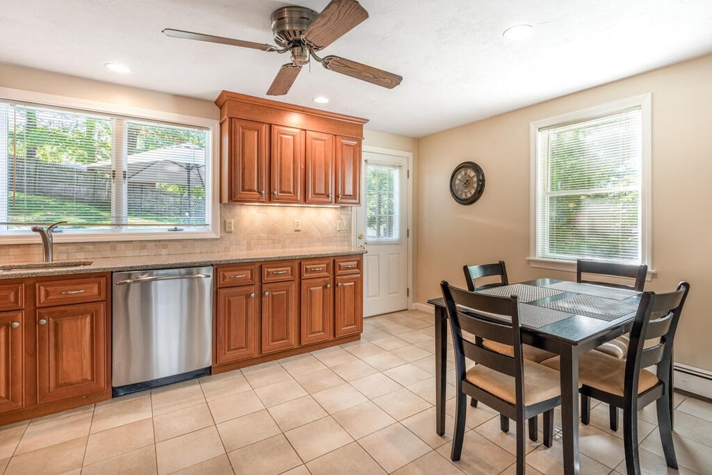 172 Virginia Road Waltham, MA 02453 - Photo 8 of 26 a kitchen with granite countertop wooden cabinets a dining table and chairs